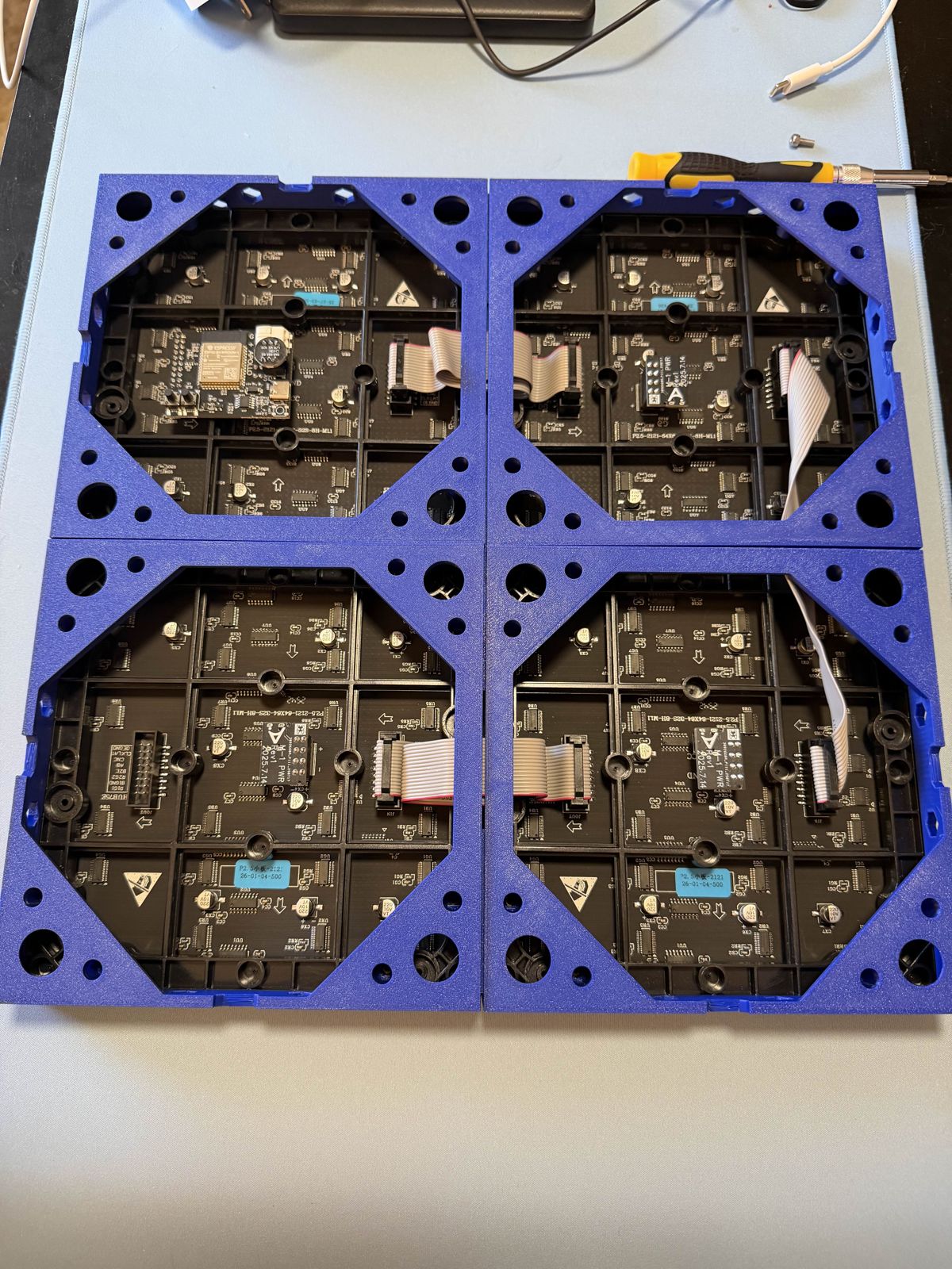 The back of the 2x2 matrix, with ribbon cables chaining the four panels and the bottom two mounted upside down.